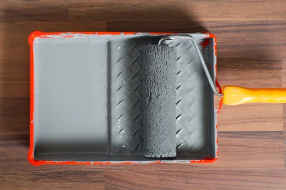 Farbwanne mit grauer Farbe und Farbrolle